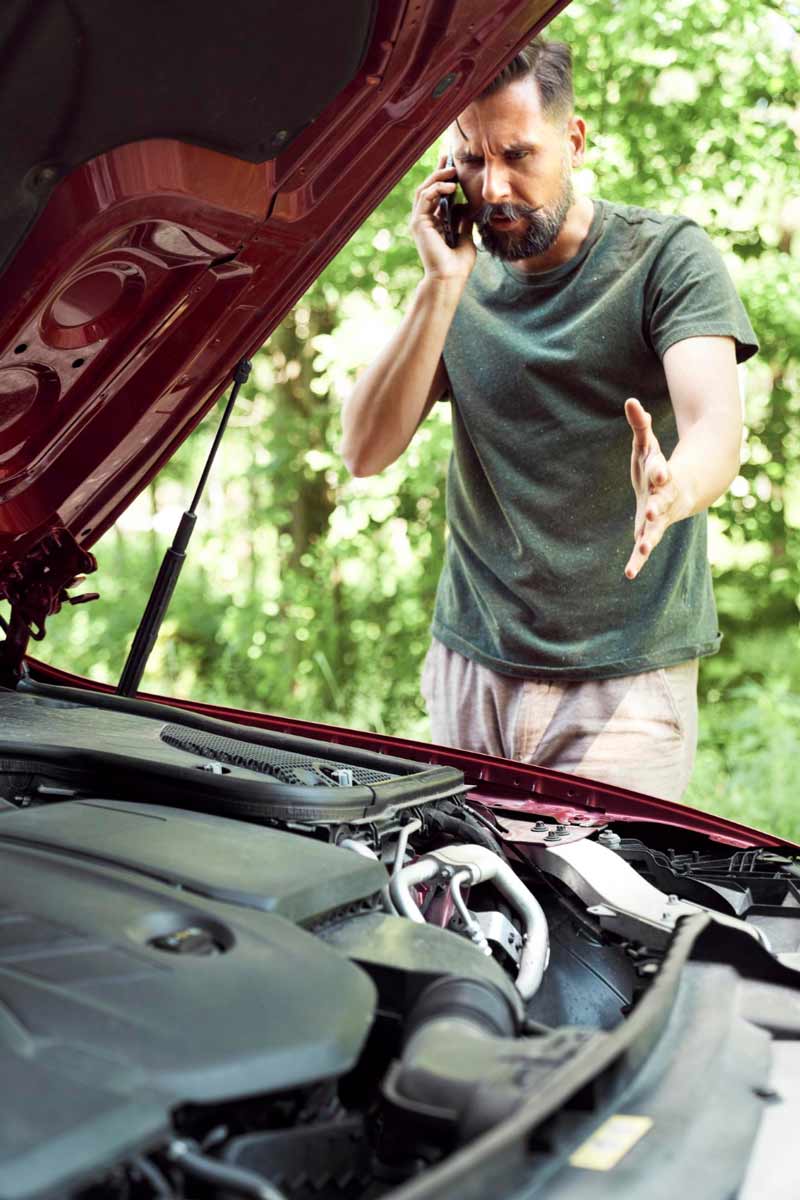 Junger Mann prüft Getriebeschaden bei Schrottauto Ankauf Alzey